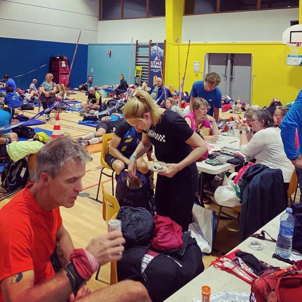 TDS runners in Beaufort aid station eating, changing gear and resting.